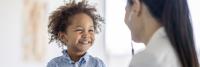 Young boy smiles at doctor during examination.